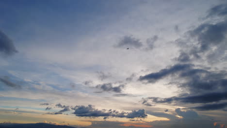 Silhouette-Of-Airplane-Flying-Across-Sky-And-Out-Of-Frame-During-Stunning-Beautiful-Sunset