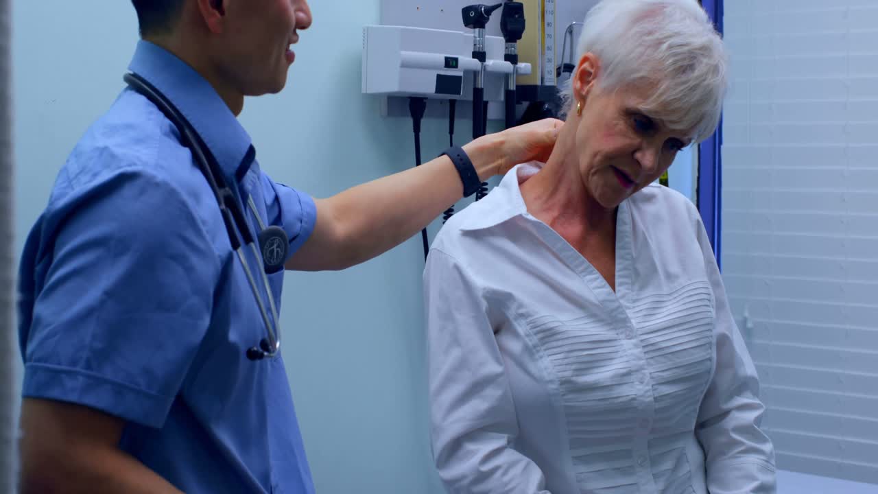Young Asian male doctor examining a senior patient in the clinic 4k