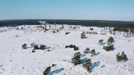 Drone-View-on-Radio-Kootwijk-Cathedral-in-Sunny-Winter-Day-with-Snow-Covered-Ground