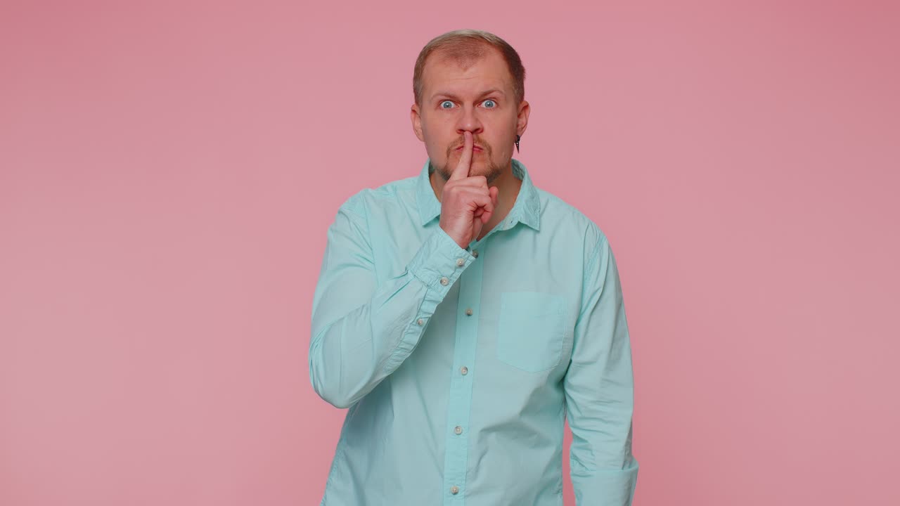 El hombre presiona el dedo índice a los labios hace silencio gesto señal no dice secreto shh estar callado