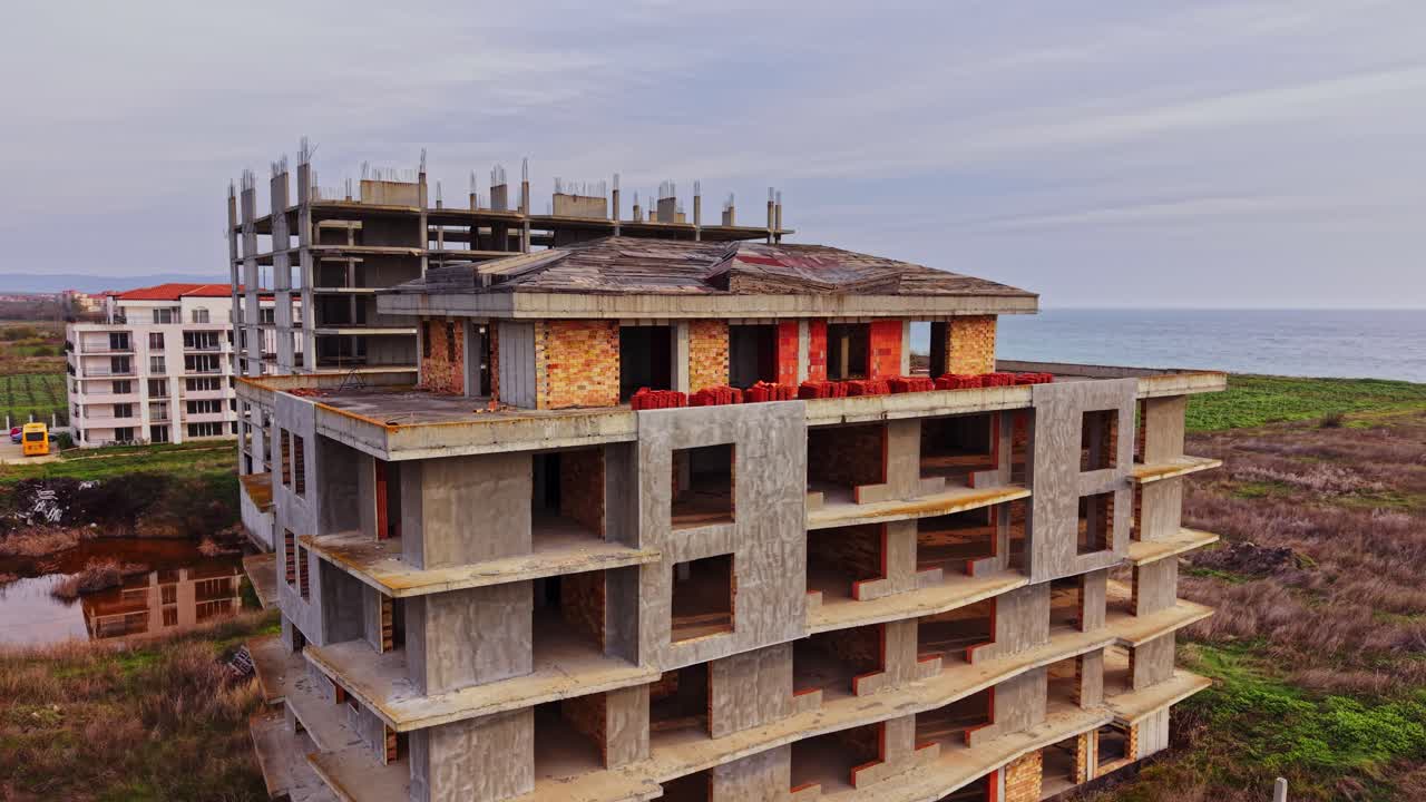 View of abandoned buildings near the coastline at sunset