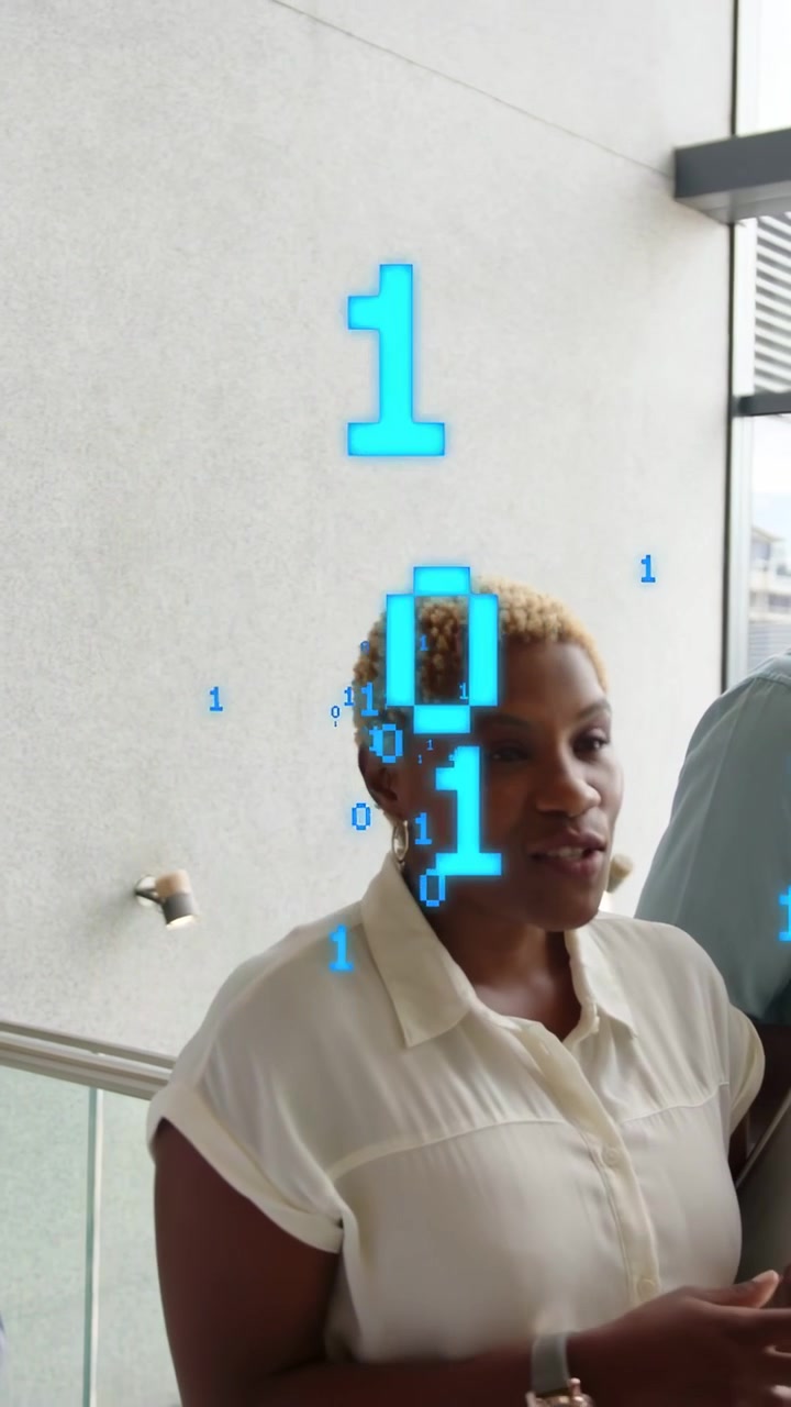 Vertical video: Woman showing tech by tapping tablet, explaining to team as blue AR binary floating