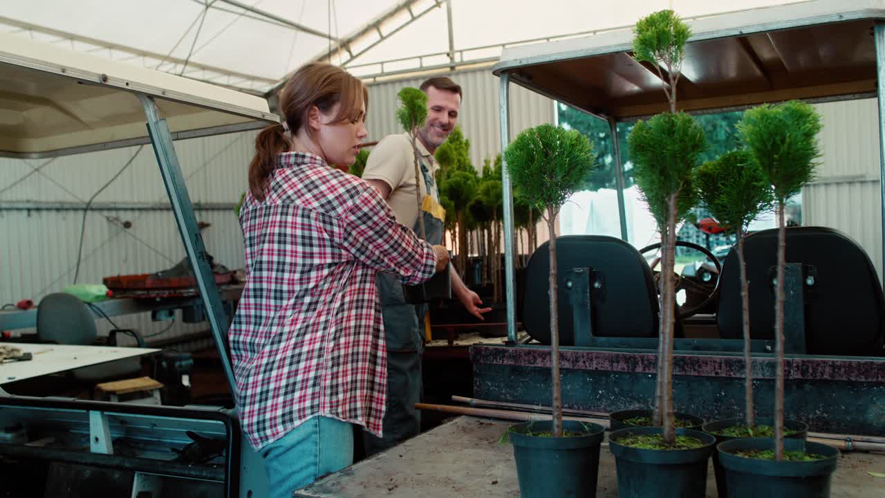 dos botánicos caucásicos trabajando en el invernadero sobre las plantas de siembra