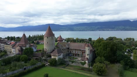 establishing drone shot of chenaux castle in estavayer-le-lac with lake neuchatel in fribourg switzerland