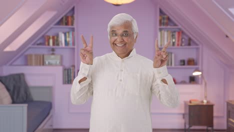 happy indian old man showing victory sign