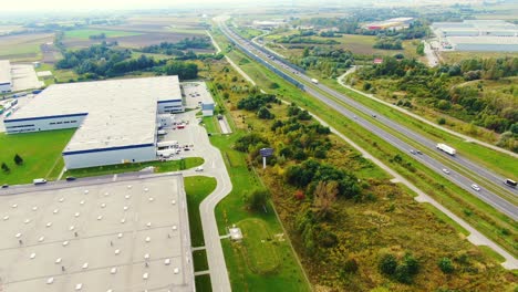 gran terminal logística en el campo cerca de la autopista, tráfico del centro de entrega en la toma aérea de la autopista