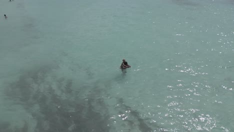 AERIAL:-Drone-shot-of-couple-having-fun-in-the-ocean