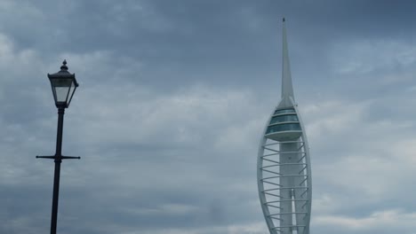 The Spinnaker Tower in Portsmouth, next to a Victoria lamppost on a cloudy day