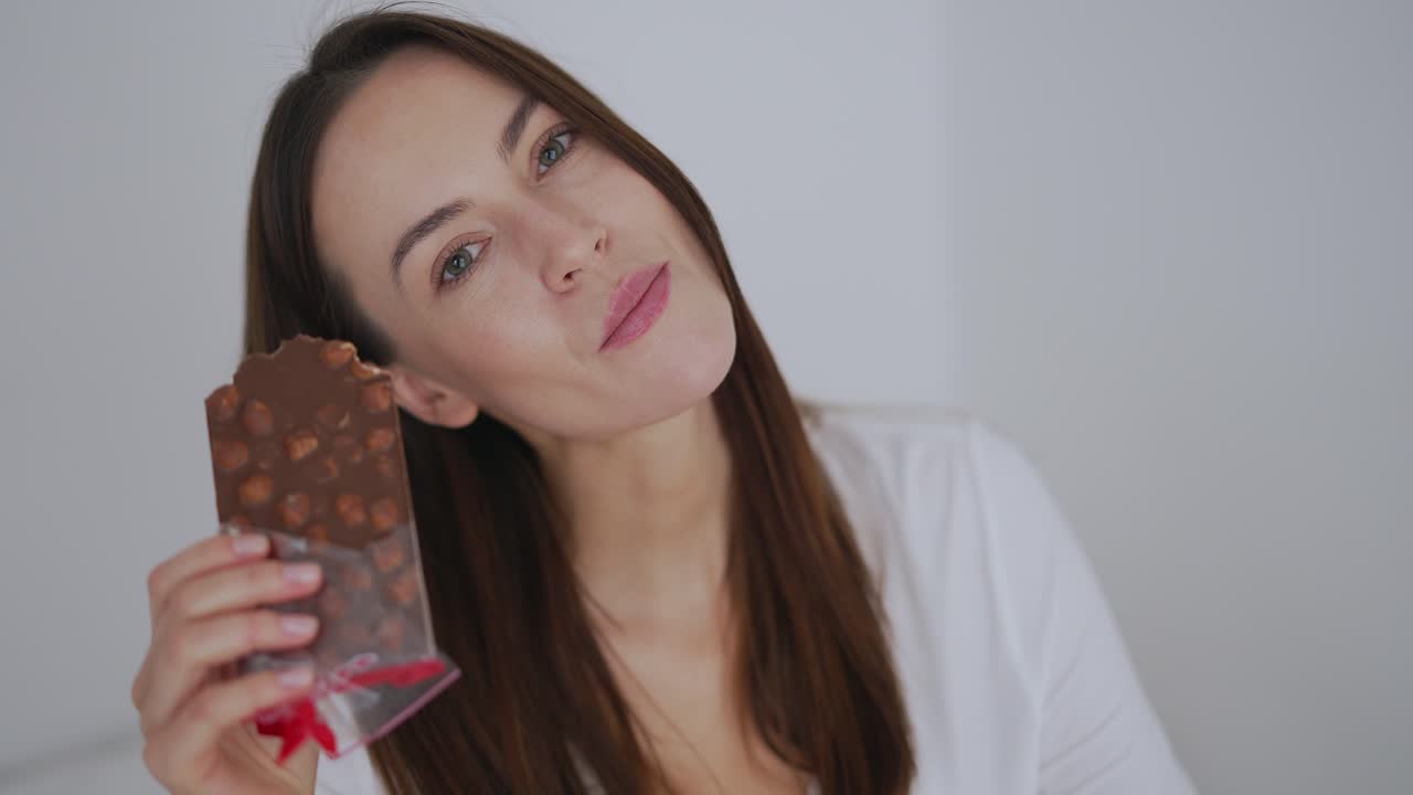 mujer disfrutando de una barra de chocolate de avellana