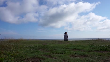 Woman-Sitting-on-a-Cliff