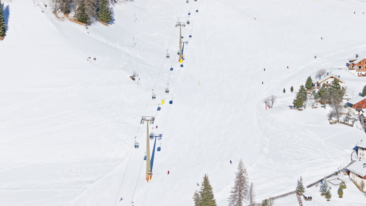 Aerial drone view of the Colfosco mountain village covered in snow, in South Tyrol, Dolomites, Northern Italy