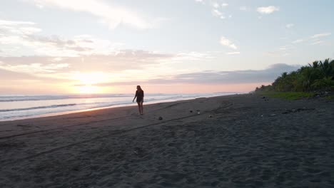 Mujer-Joven-Que-Regresa-Del-Cálido-Océano-Pacífico-Sur-Durante-La-Puesta-De-Sol-Y-Camina-Hacia-La-Cámara-En-Cámara-Lenta