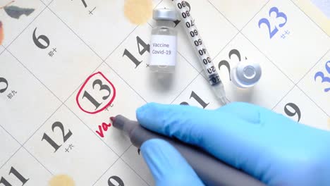 vaccine day concept glass ampoule with vaccine and syringe on calendar