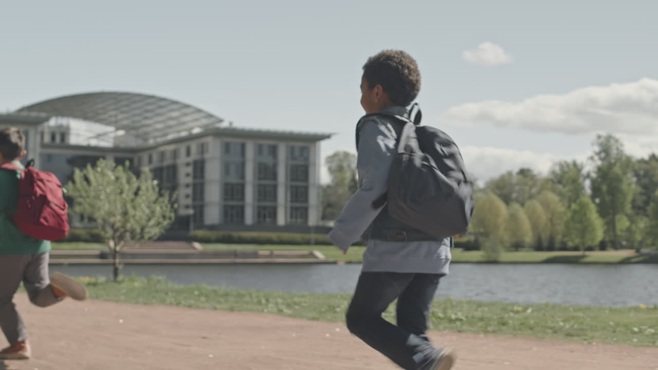 Boys Running with Backpacks in Park