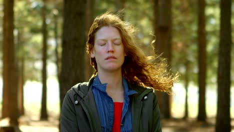 mujer de pie con los ojos cerrados en el bosque 4k