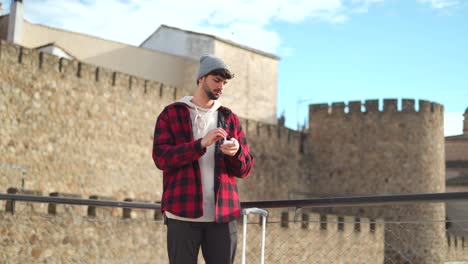 traveler with suitcase putting off earphones