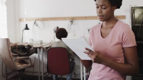 portrait of happy african american female worker in workshop in jewellery studio in slow motion