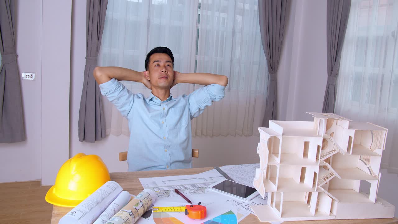 สถาปนิกหนุ่มกำลังผ่อนคลายกับโครงการสถาปัตยกรรม