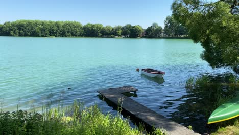 static shot of beuatiful landscape with natural lake during summer and lonely boat during covid19