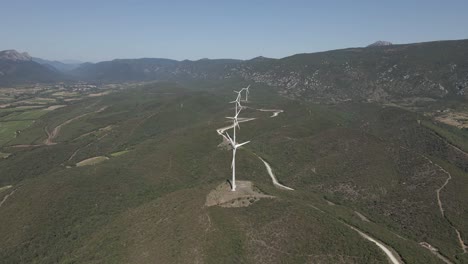 single line of wind turbines in lush green foothills valley in france