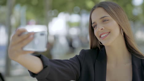 chica feliz tomando una selfie con su teléfono inteligente