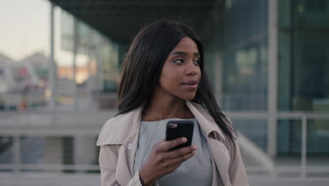 portrait of african american business woman using phone in city stylish executive wearing coat