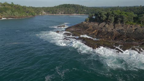 estableciendo una toma aérea de un dron que revela la bahía de hiriketiya detrás del promontorio en el sur de sri lanka