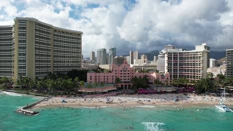 a drone glides from side to side over the ocean revealing a tropical location filled with water front beach luxury hotels