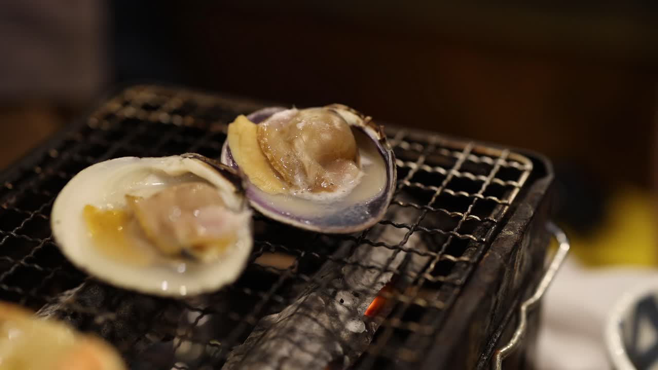 Oysters cooking on a grill, steam rising