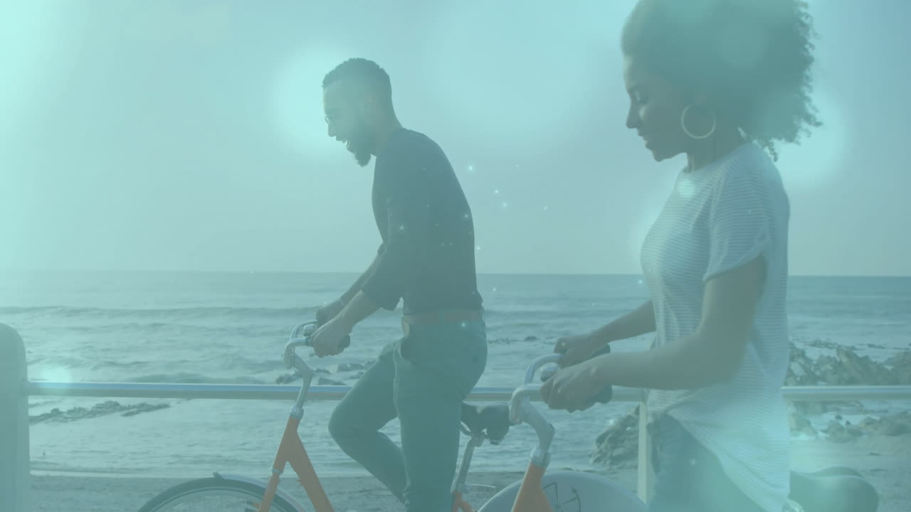 man and woman cycling along beachfront promenade, displaying animated health charts and heart icons