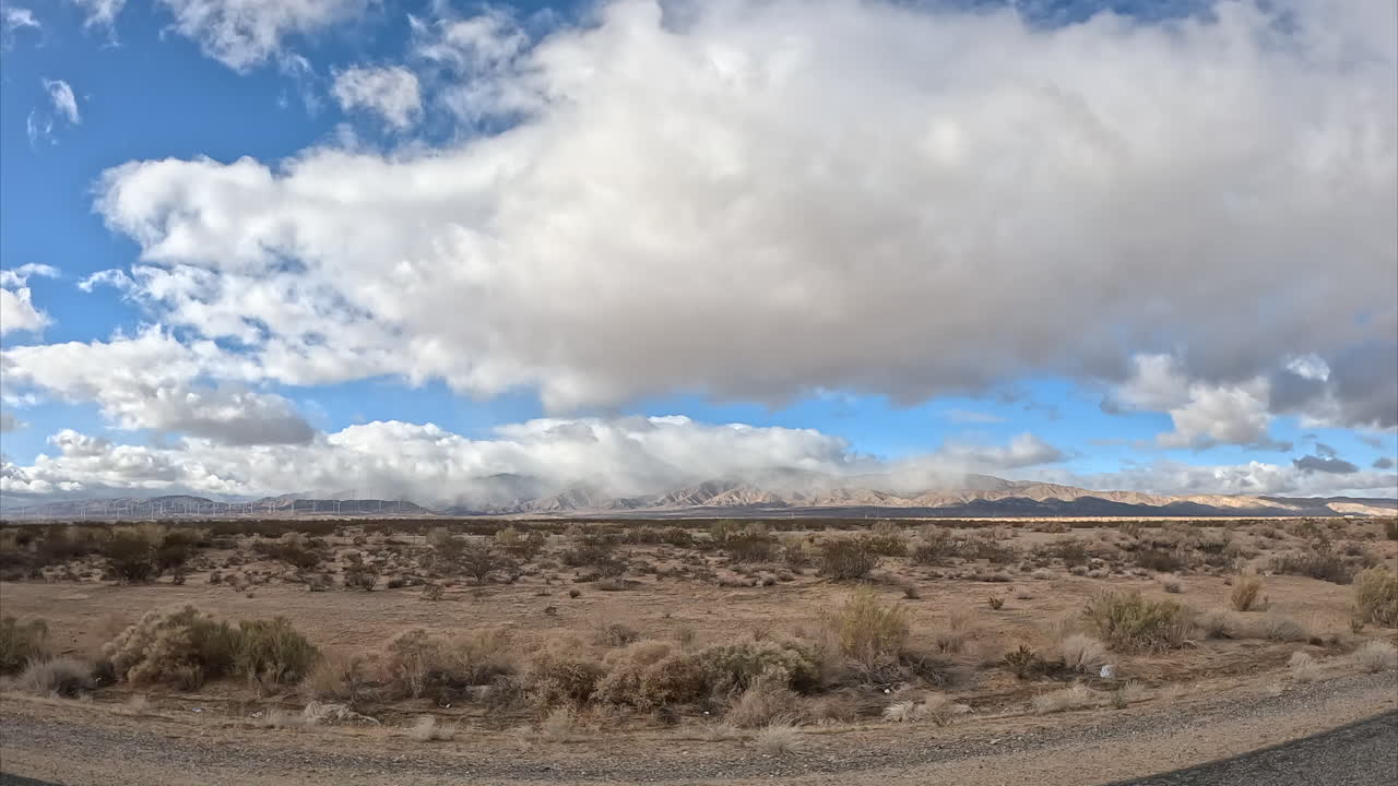 conduciendo a través del vasto paisaje del desierto de mojave mientras mira por la ventana del pasajero