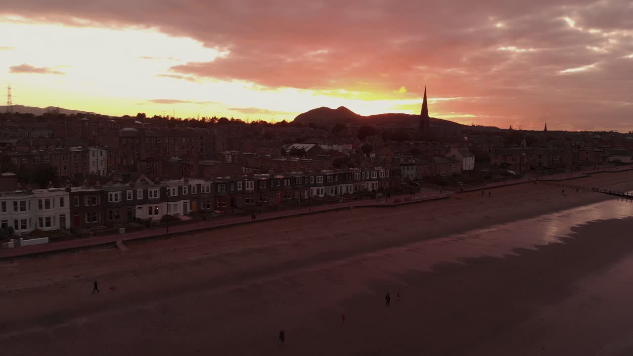 Beautiful Portobello Beach in Edinburgh during dramatic sunset- Aerial descending panning left to right