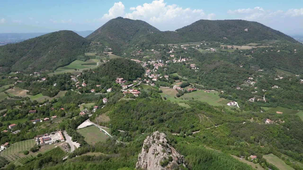 Riprese aeree con drone del Monte Pendice in Italia: formazioni rocciose aspre, pendii boscosi e paesaggio panoramico dei Colli Euganei sotto la luce naturale. Ideale per progetti di natura e viaggio.