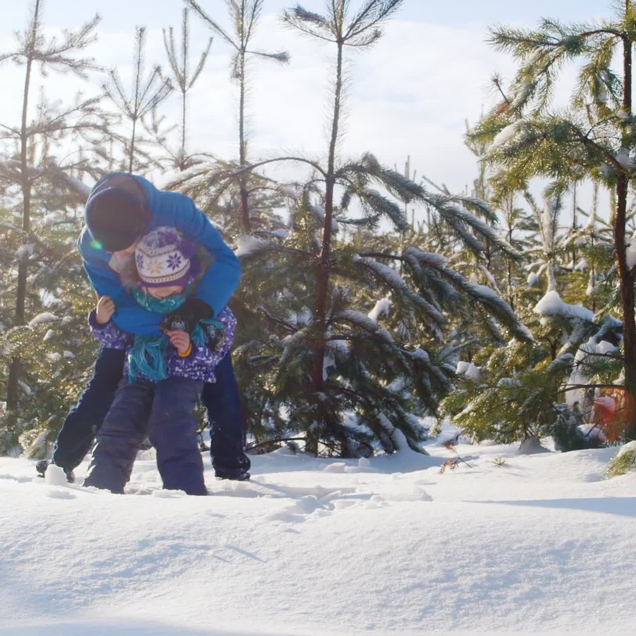 hermano juega con su hermana menor en la nieve