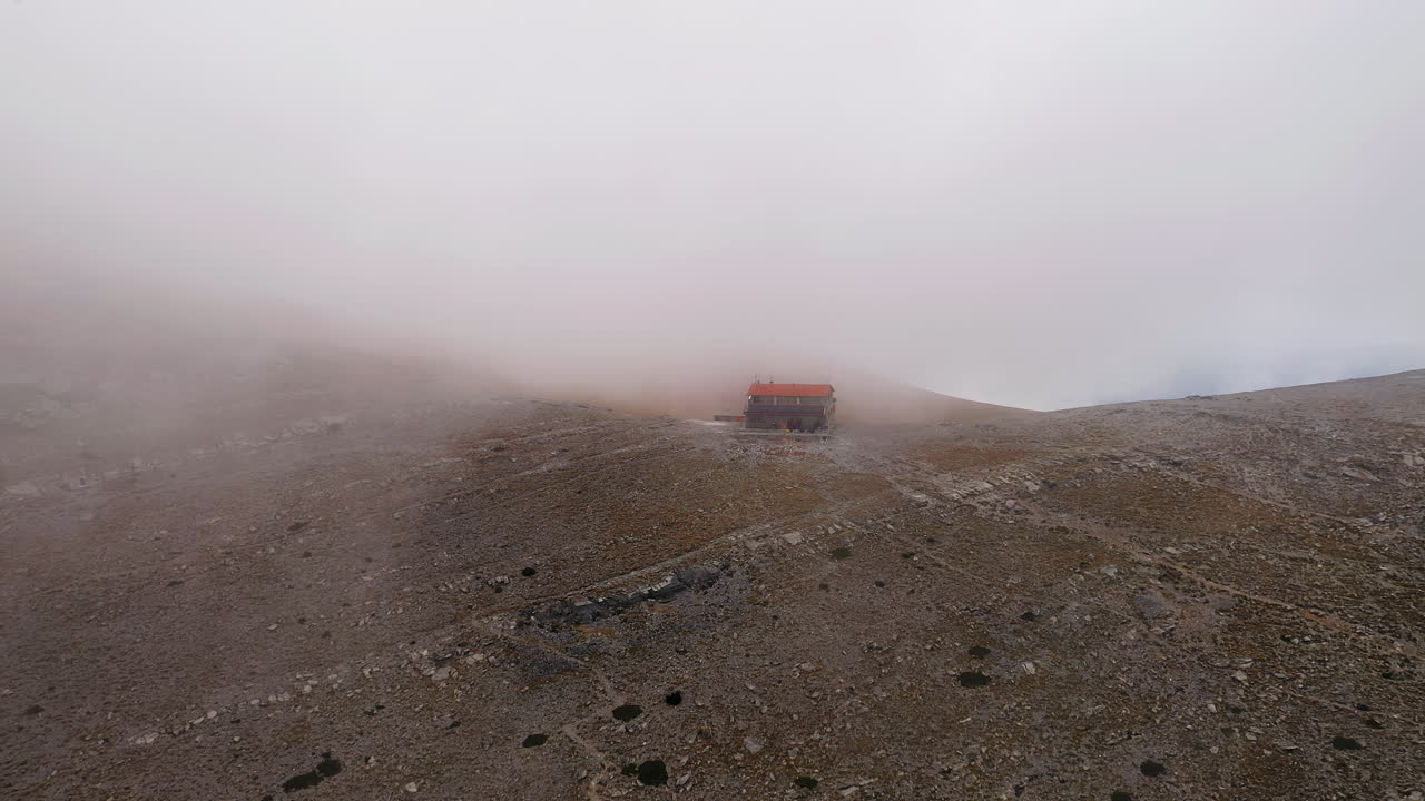 Mountain cabin Giosos Apostolidis Refuge Mount Olympus Greece covered in fog mist aerial drone