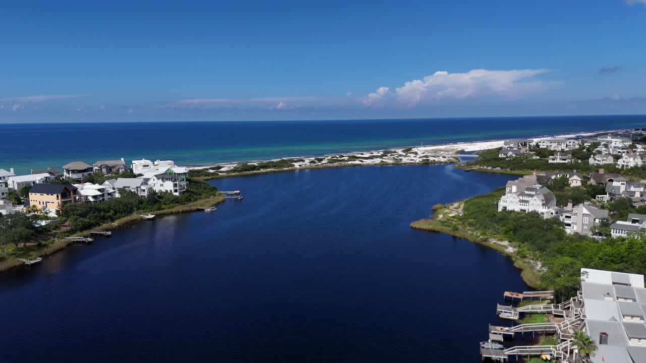 Aerial fly over coastal Camp Creek Lake with houses with connection between banks, 30A, Florida, USA