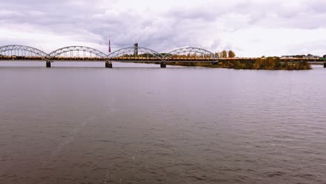 Hyperlapse-Eines-Güterzuges,-Der-Waggons-über-Die-Eiserne-Eisenbahnbrücke-In-Der-Innenstadt-Der-Stadt-Rige,-Lettland,-Transportiert