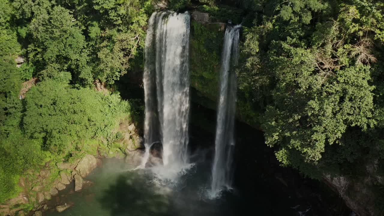 retroceso aéreo sobre la cascada de misol-ha rodeada de árboles y vegetación en méxico