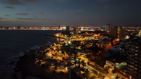 Aerial-view-following-the-Mazatlán-Malecon,-colorful-dusk-in-Sinaloa,-Mexico