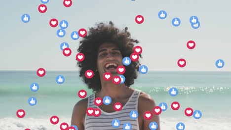 animation of like and love digital icons over smiling man on beach