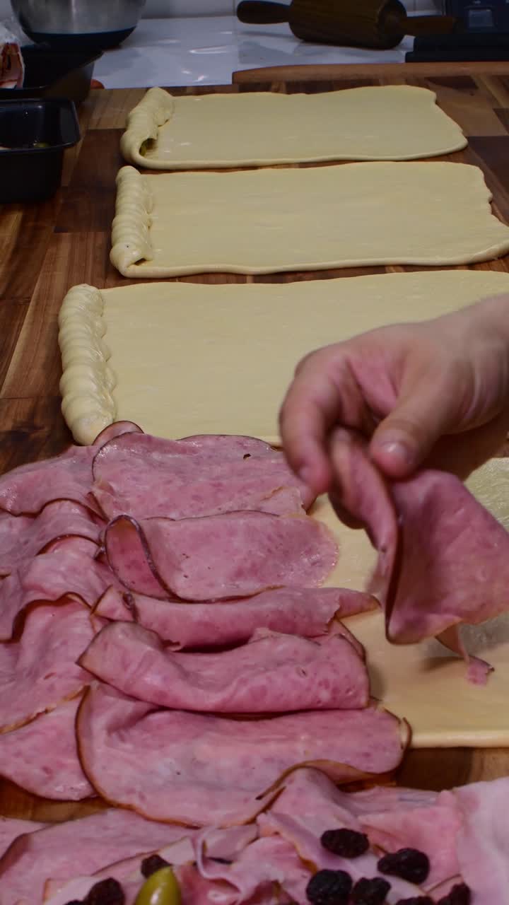 Preparazione di prosciutto per il ripieno della pasta su un tavolo di legno, allestimento culinario accurato.