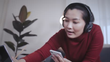 freelance woman redshirt using tablet with headphone for meeting online at home