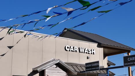 generic car wash building with blue and white flags waving in the breeze