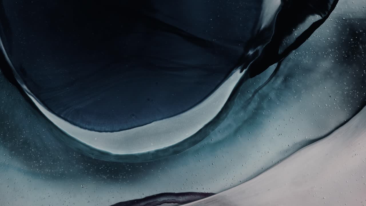 влажное голубое чернило трансформируется и расширяется, течет в круговых рисунках, как океан, волновые образования, макро, медленно расширяется