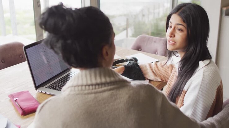 Video di donne birazziali concentrate che lavorano da casa con il laptop