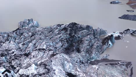 Toma-En-órbita-Lenta-Del-Glaciar-Fjallsárlón-Derritiéndose-En-La-Laguna-En-Islandia