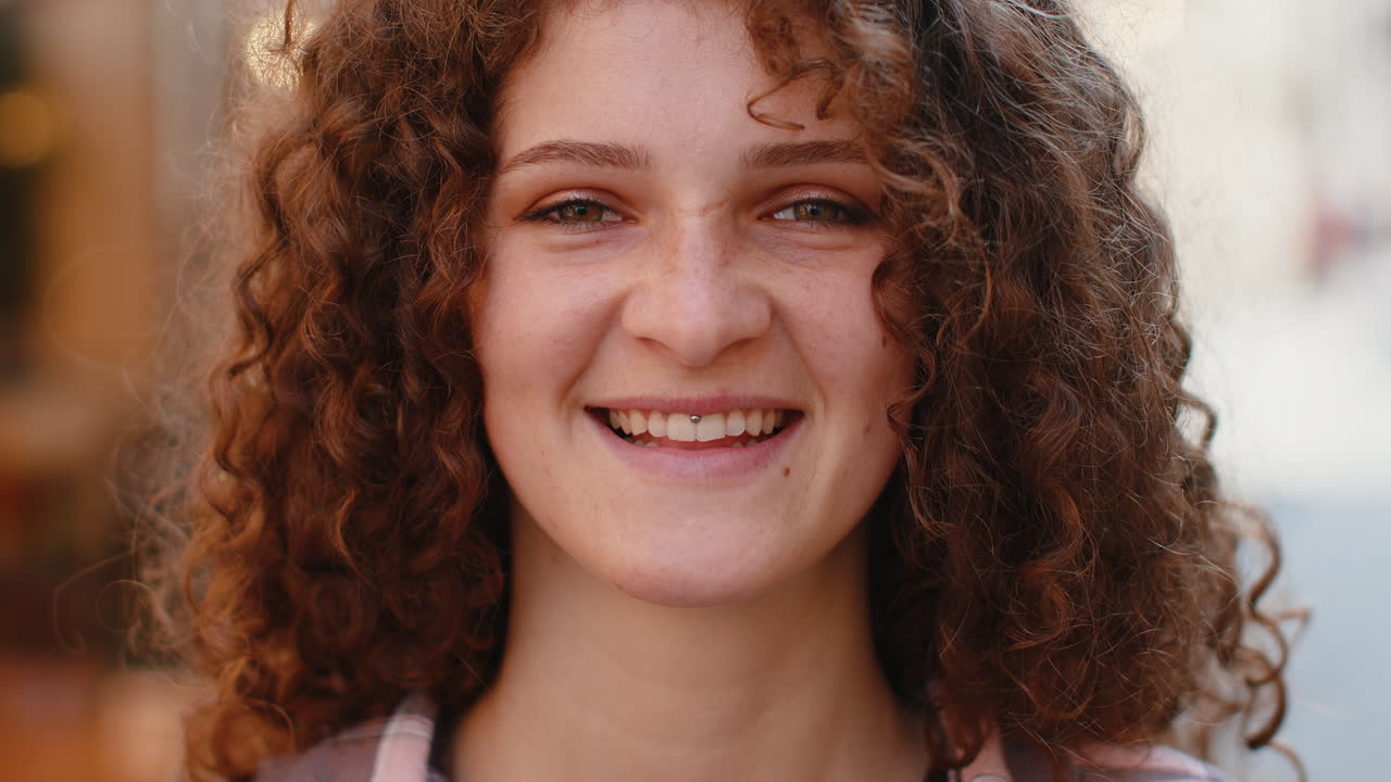 feliz mujer joven sonriendo mirando lejos soñando descansando buenas noticias sentirse satisfecho en la calle de la ciudad