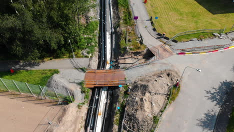 sitio de construcción, tuberías de calefacción en la zanja al aire libre, antena de arriba hacia abajo