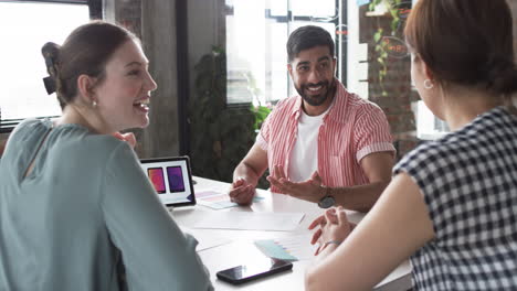 young caucasian woman and asian man engage in a lively business discussion with another person