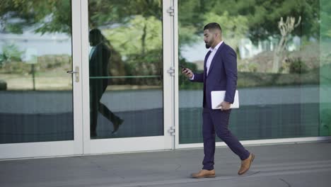 Concentrated-businessman-using-smartphone-on-street